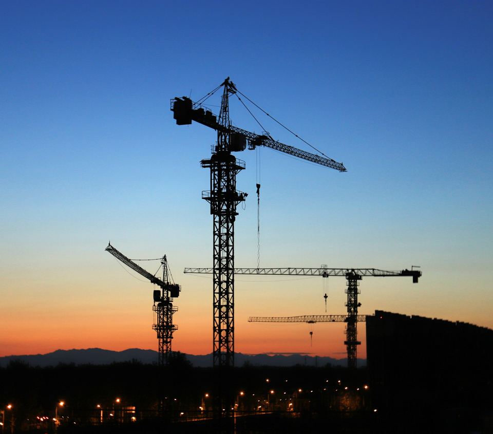 Chantier avec grues à tour au coucher du soleil