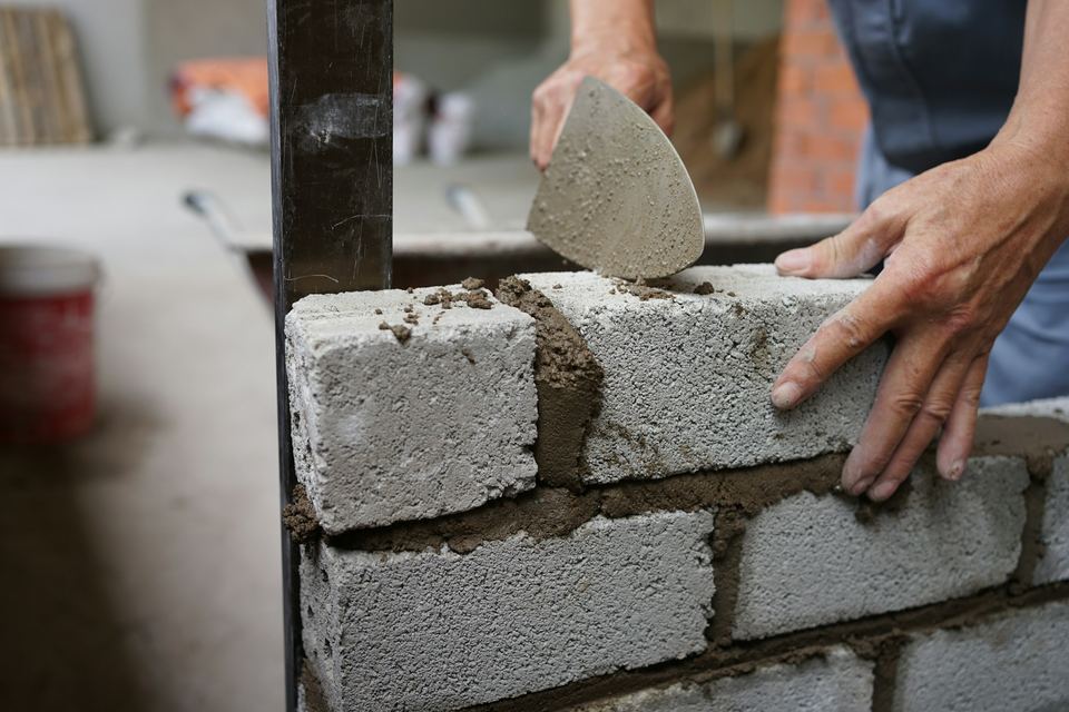 Mortier appliqué sur un mur de briques