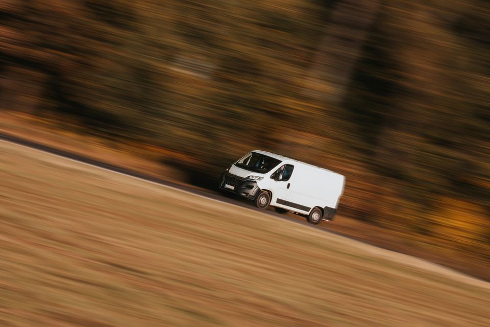 Voiture blanche roulant sur une route de campagne
